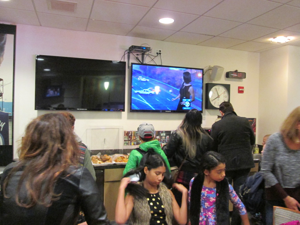 The regular-people Green Room. It had a TV running the show, with a clock and "on air" sign, plus standard office furniture. It was quite crowded. Copyright Deborah Abrams Kaplan